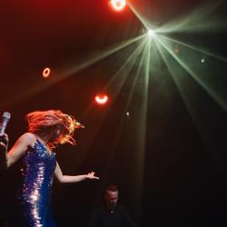 Singer on a dark stage, lit up by stage lights