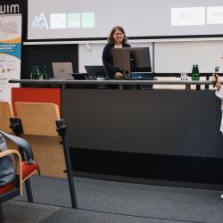 Person giving to a presentation in an auditorium