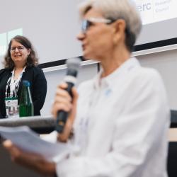 Person giving to a presentation in an auditorium