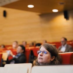Lecture room with people listening to a presentation
