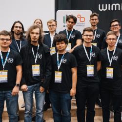 People posing for a foto in front of posters