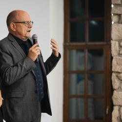 Two people, one talking to a microphone