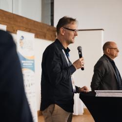 Two people, one talking to a microphone