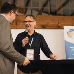 Two people, one talking to a microphone