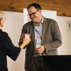 People giving and receiving gifts in a banquet hall
