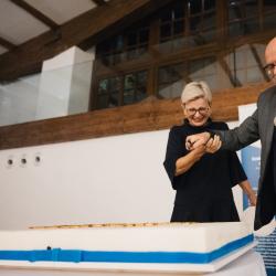 People next to a big birthday cake